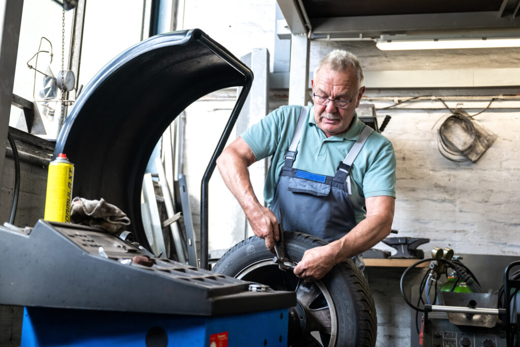 Alter Mann arbeitet an einem Auto