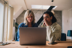 Eine Frau und ein Mann sitzen an einem Laptop